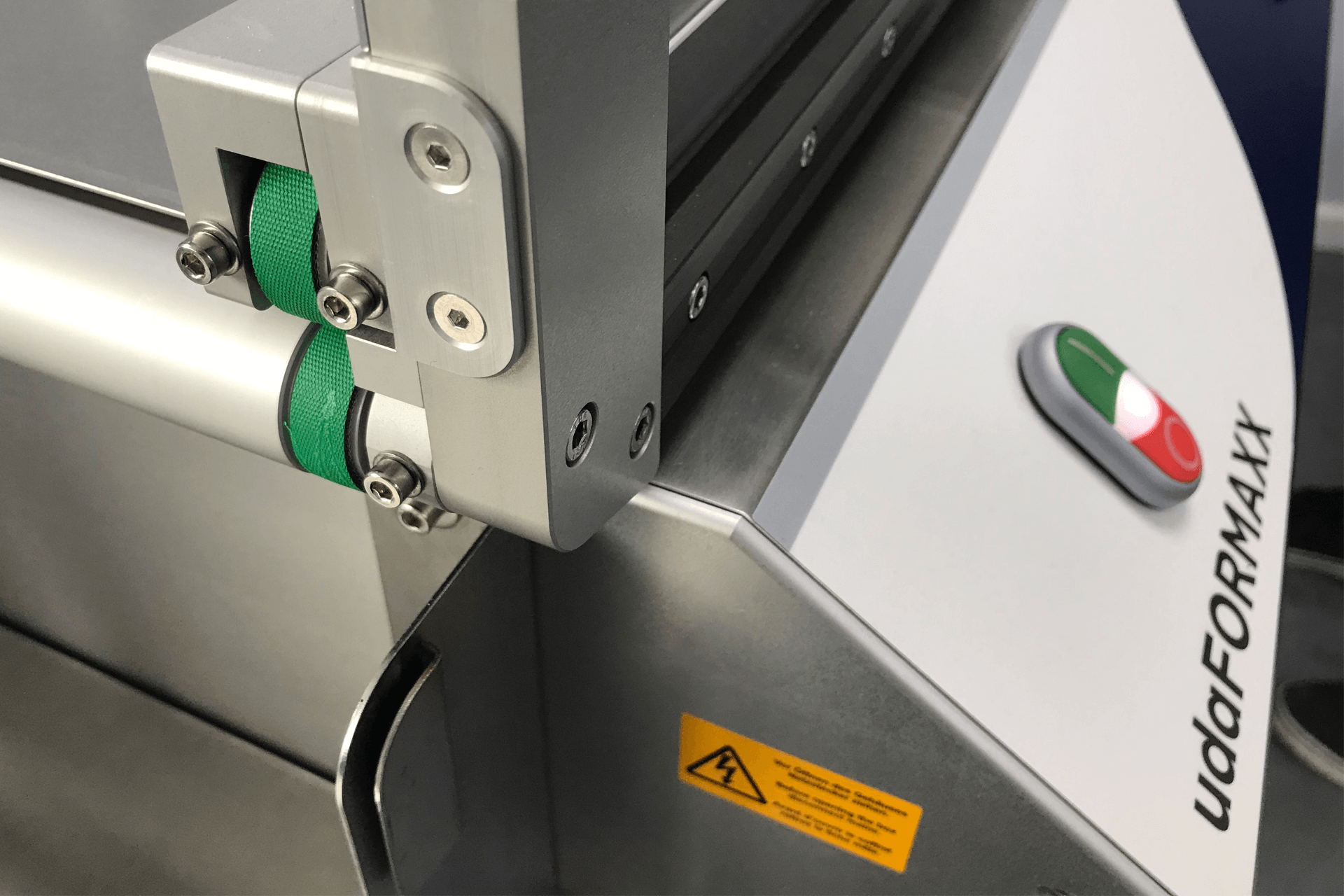 Green belts on a roller on the udaFORMAXX carton feeder